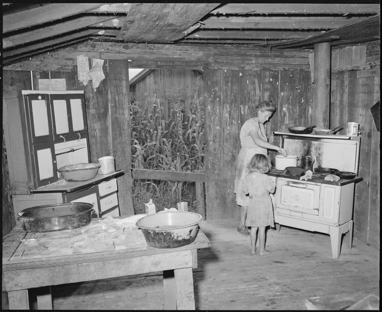 Mère et enfant dans une petite cuisine, scène de préparation du quotidien.
