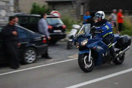 Motocyclistes de la Garde républicaine encadrant un passage routier, motos en file et public massé derrière les barrières.