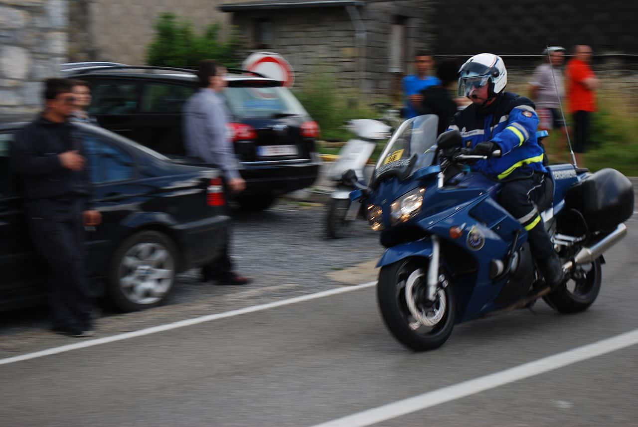 Motocyclistes de la Garde républicaine encadrant un passage routier, motos en file et public massé derrière les barrières.
