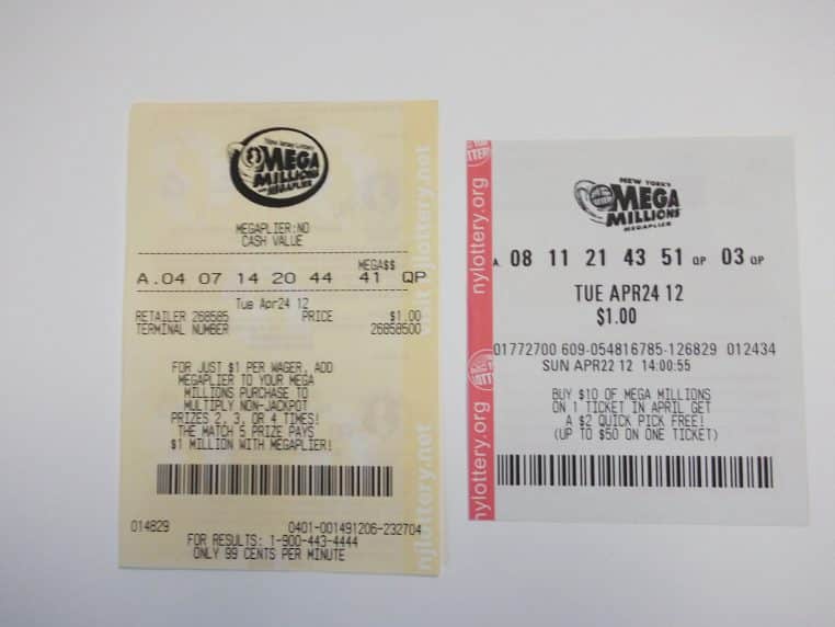 Gros plan sur deux tickets Mega Millions posés côte à côte, montrant des combinaisons et logos, contexte loterie américaine moderne.