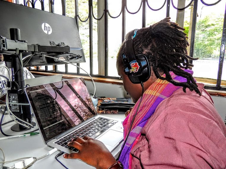 Développeur logiciel concentré dans un bureau à Nairobi, illustrant l’automatisation croissante de tâches techniques par les outils d’intelligence artificielle.