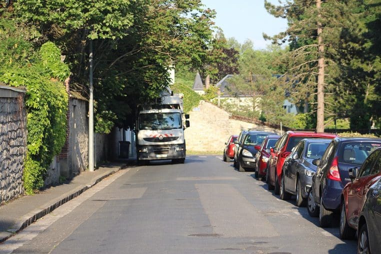 Rue de Fontainebleau avec benne à ordures en service, camion arrêté le long du trottoir au cœur d’un quartier résidentiel calme.