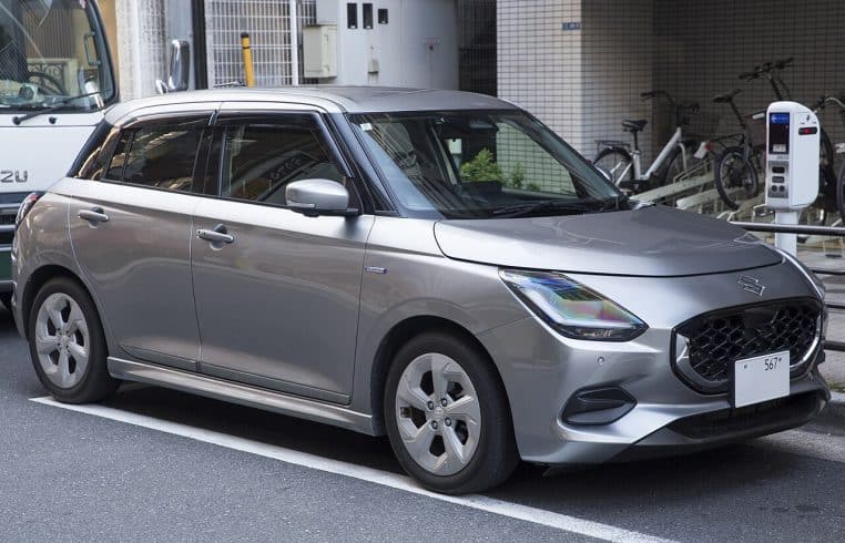 Suzuki Swift 2024 argent trois-quarts avant stationnée en extérieur.