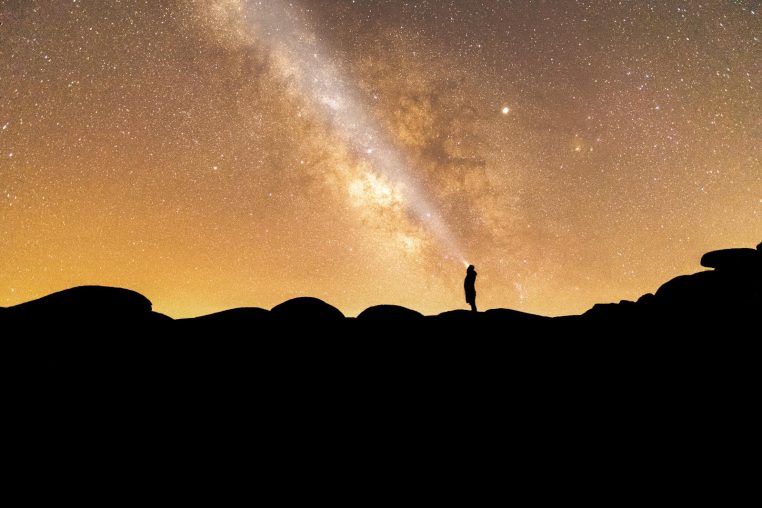 Silhouette of a person gazing at the Milky Way in Bafa, Türkiye, under a starry sky.