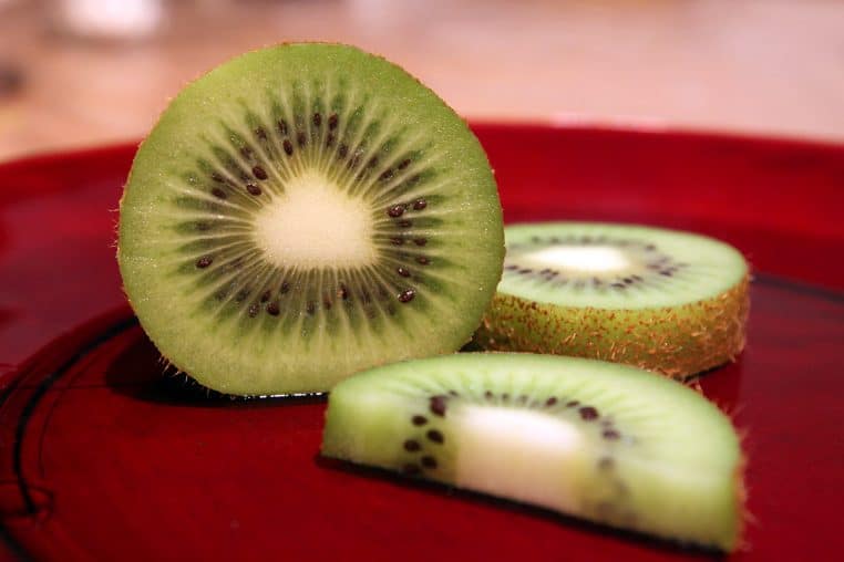 Kiwi vert tranché montrant la chair et les graines.