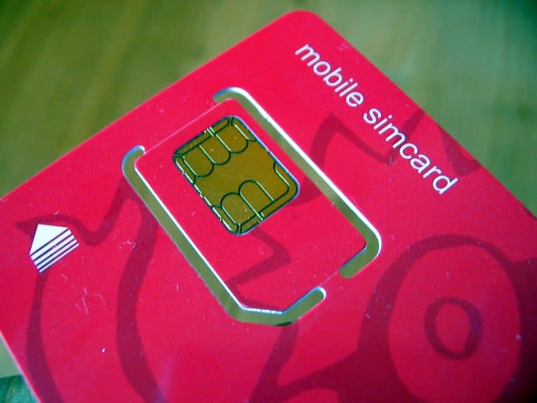 Carte SIM rouge posée sur un fond assorti, vue macro