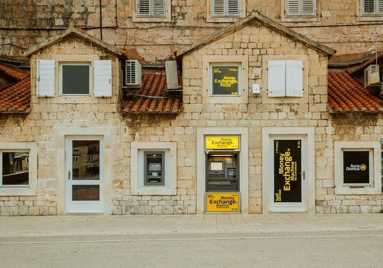 DAB encastré dans un bâtiment ancien, symbole du retrait des pensions.