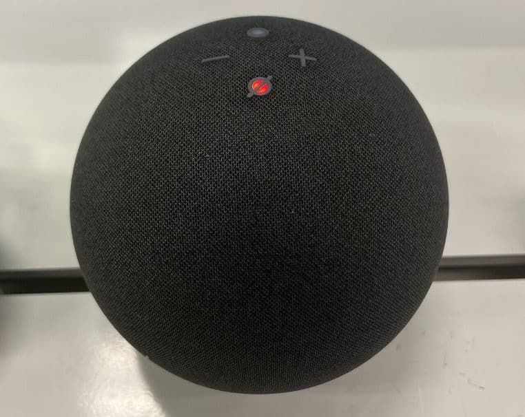 Enceinte Amazon Echo posée sur table, arrière-plan flou.