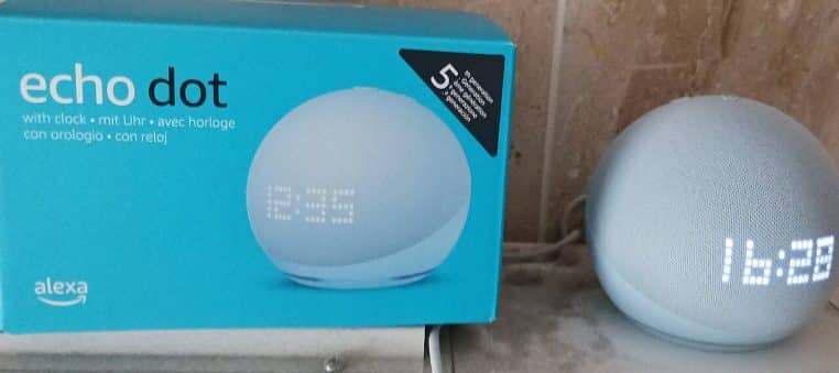 Echo Dot 5e génération avec horloge, vue de face sur buffet en bois.