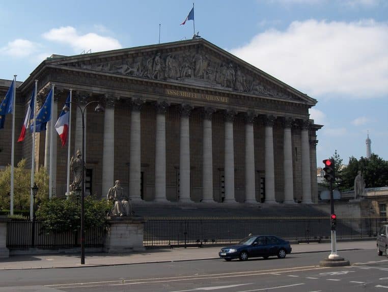 Façade du Palais-Bourbon avec fronton et drapeau français.