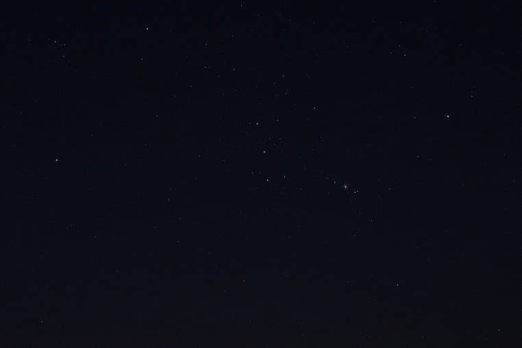 Paysage nocturne à Tenerife avec la constellation d’Orion au-dessus de l’horizon, ciel sombre et étoiles nettes.