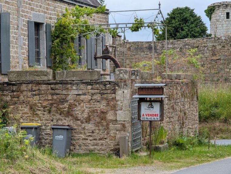 Bâtiment affichant « À vendre » près du château de Tonquédec, exemple d’annonce immobilière en Bretagne.
