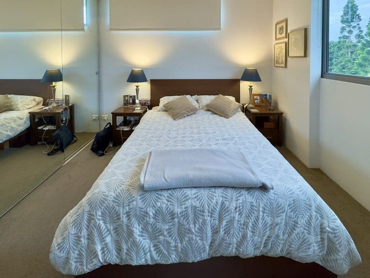 Chambre contemporaine lumineuse, table de chevet épurée et rangement discret, exemple moderne d’espace nuit ordonné.