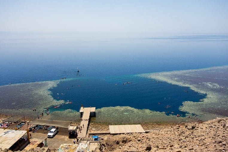 Point de vue côtier sur le Blue Hole de Dahab, contraste marqué entre bleu profond et plateau peu profond.