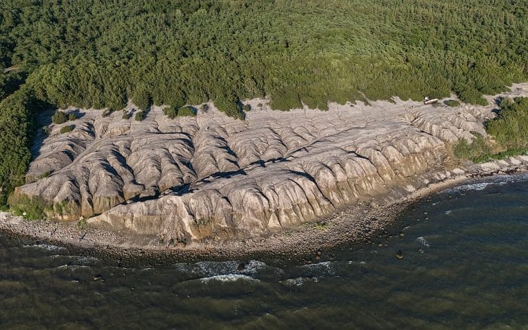 Photographie aérienne d’un ancien site d’enfouissement, illustrant les contraintes techniques d’une recherche dans un environnement de déchets.