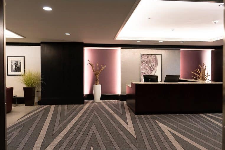 Salon lumineux avec grande baie, canapé et plantes, ambiance cosy