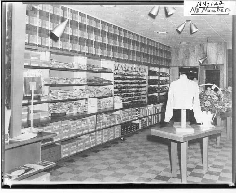 Vue intérieure d’un magasin de vêtements avec rayonnages alignés et portants, photo d’archives en format horizontal haute définition.