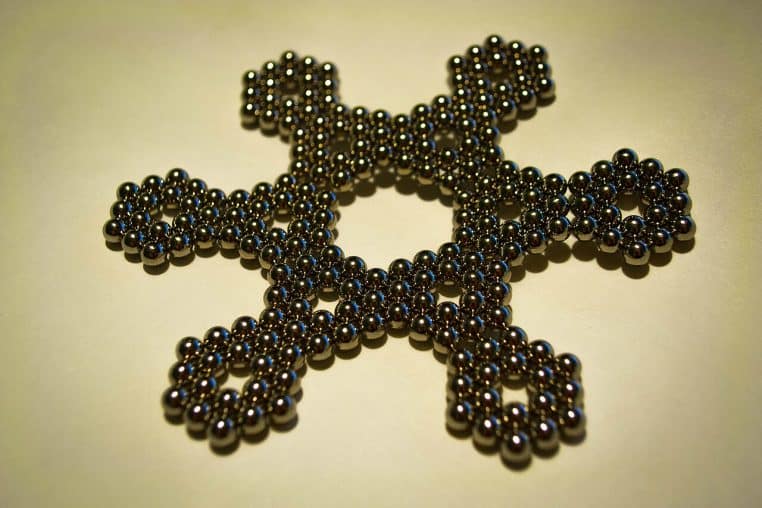 Ensemble de billes aimantées en motif géométrique, photographiées en gros plan pour montrer l’assemblage et la brillance métallique.