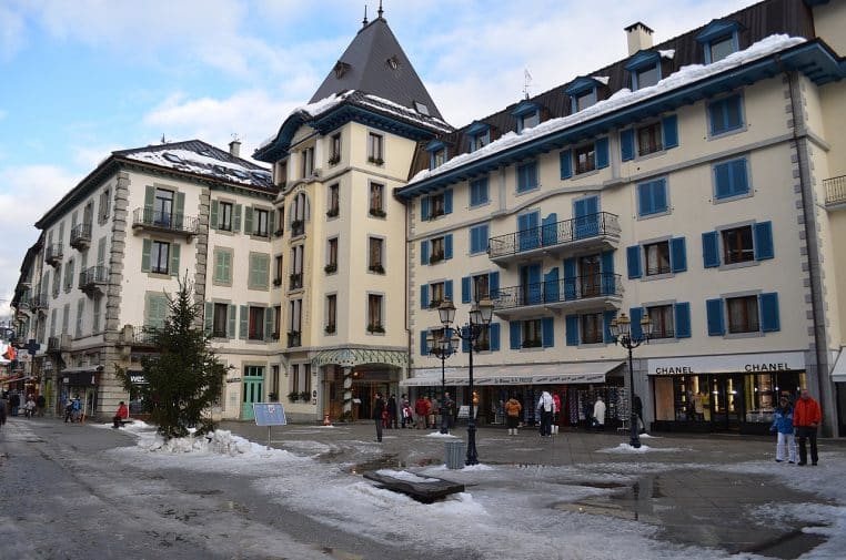 Aiguilles du massif du Mont-Blanc éclairées par le soleil d’hiver au-dessus de la forêt.