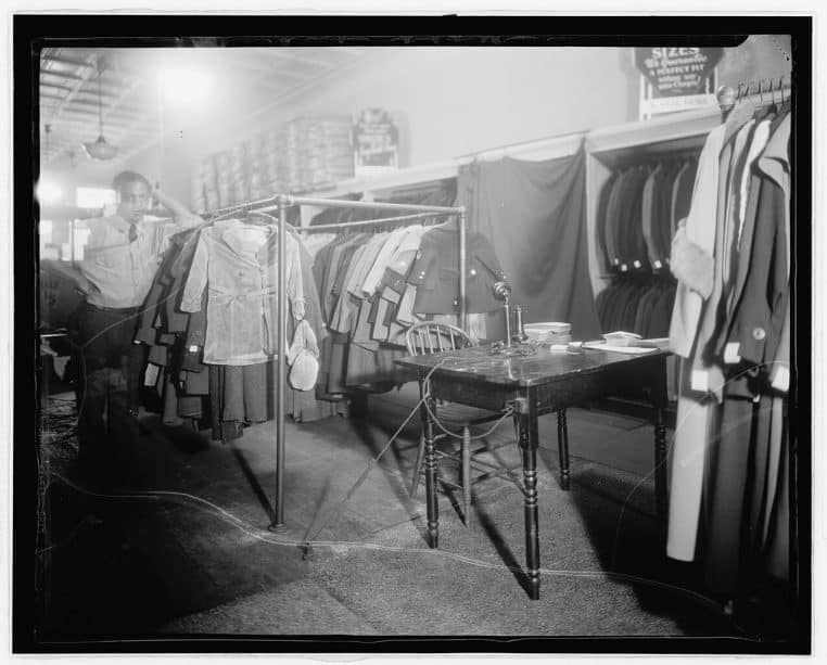 Large vue d’archives d’un intérieur de magasin de vêtements avec portants et étagères, photo en format paysage.