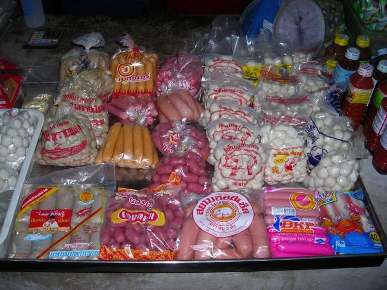 Rayon de marché présentant différentes viandes et charcuteries emballées sous vide en sachets transparents.