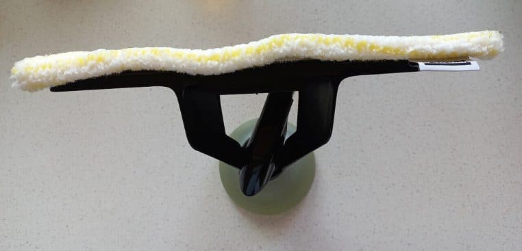 Spray, chiffon microfibre et aspirateur de vitres posés sur une table