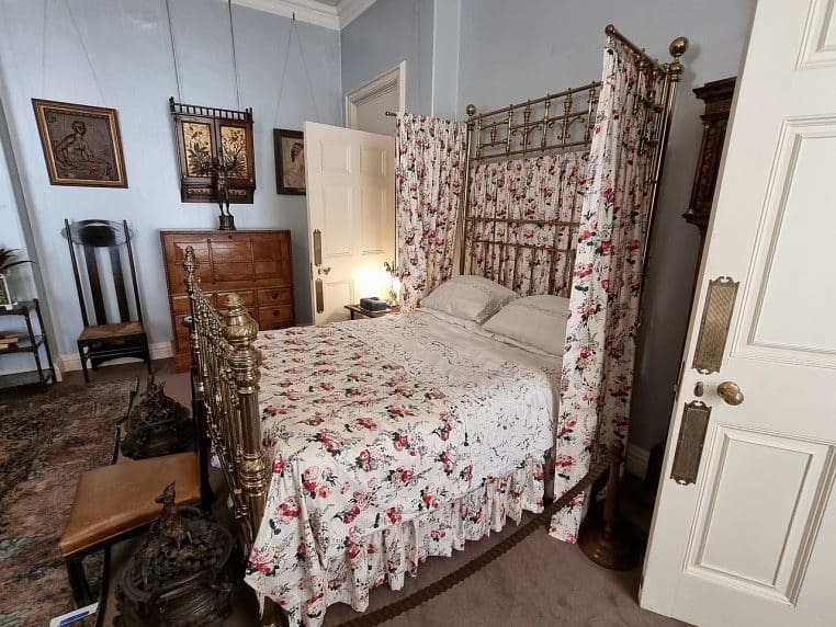 Chambre avec lit en laiton poli, surfaces dégagées et organisation simple, rappelant l’importance d’un visuel apaisé.