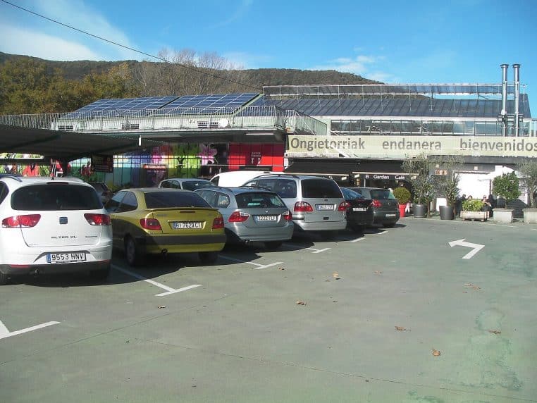 Façade et parking d’un grand centre de jardinage Endanea à Hondarribia, avec verrières et panneaux solaires, un jour ensoleillé.