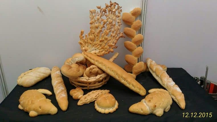 Vitrine boulangerie d’une grande surface avec pains et étiquettes de prix.