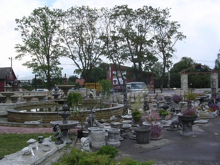 ayon extérieur d’une jardinerie à Rakvere avec fontaines, statues et bacs décoratifs alignés devant des arbres.