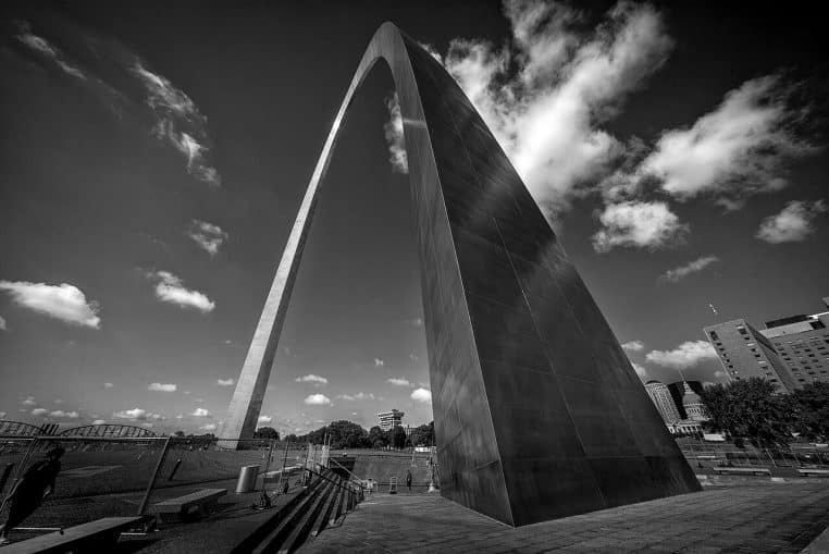 Vue large de l’emblématique Gateway Arch de St. Louis avec pelouses et ciel bleu, cadrage horizontal.