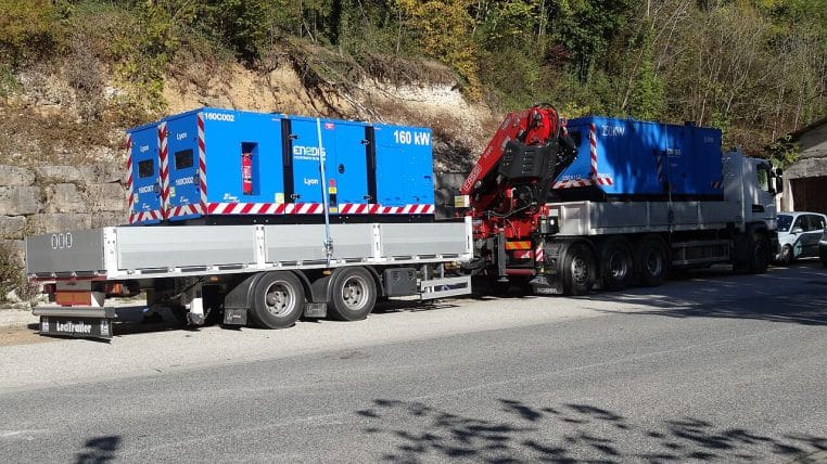 Deux groupes électrogènes Enedis de 160 et 250 kW chargés sur camion, vue latérale en extérieur.