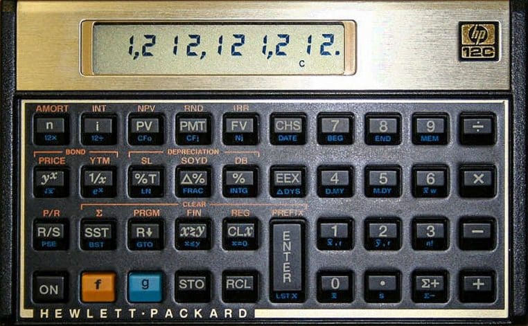 Gros plan d’une calculatrice financière HP-12C affichant des chiffres, posée à plat.