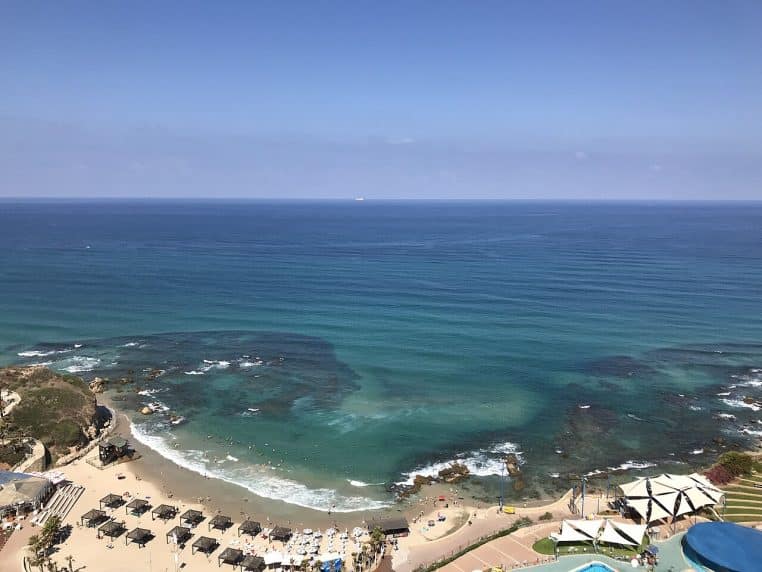 Large panorama de la côte d’Hadera en Méditerranée, avec plage et houle, zone connue pour les regroupements saisonniers de requins