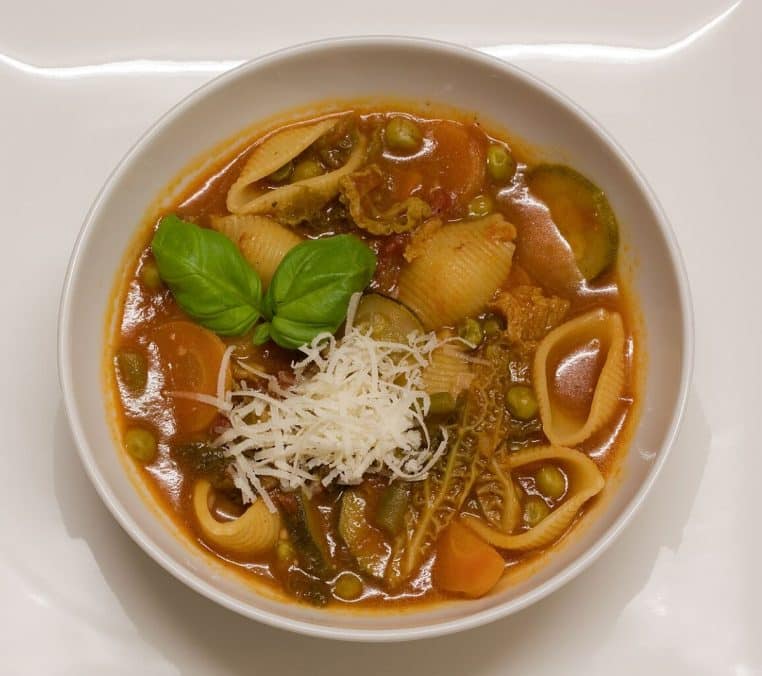 Assiette de minestrone rouge avec pâtes et légumes.