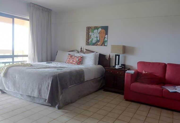 Chambre d’hôtel avec lit et canapé.