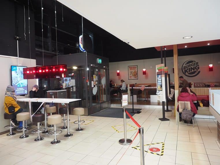 Comptoir Burger King avec éclairage chaleureux et panneaux de menu.