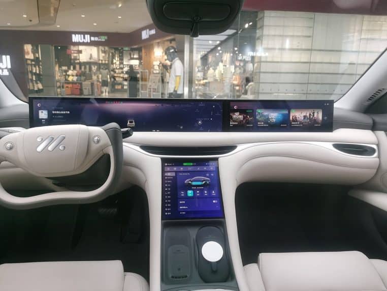 Plan large d’un tableau de bord contemporain, volant et écrans.