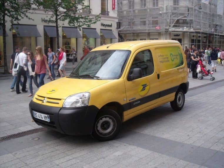 Fourgonnette La Poste circulant en ville.
