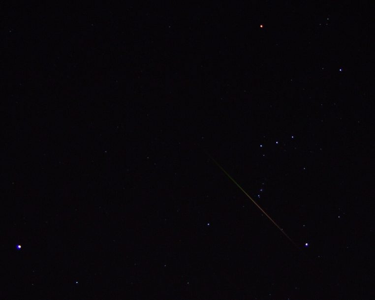 Constellation d’Orion et ciel d’automne, traînées de météores des Léonides au-dessus d’un paysage discret.
