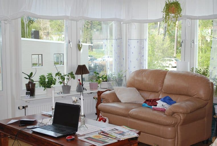 Grand salon contemporain donnant sur un jardin, radiateur visible sous les baies