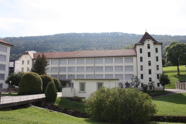 Façade latérale de l’aile ouest de la manufacture Longines à Saint-Imier, architecture industrielle et grandes fenêtres alignées.