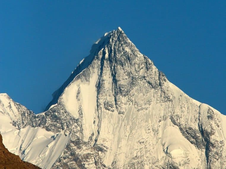 Quasi-pleine Lune au-dessus du massif de Lupghar Sar, paroi rocheuse et ciel sombre, cadrage horizontal détaillé