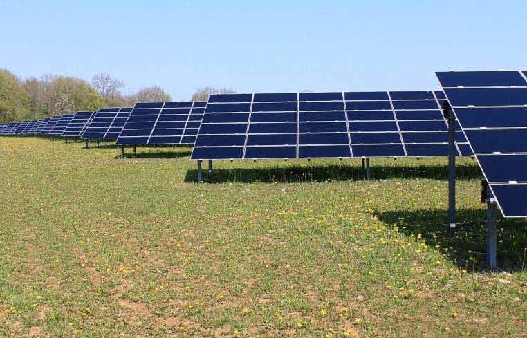 Parc photovoltaïque de Massangis vu en contre-plongée, alignements de panneaux captant le soleil d’avril sous un ciel dégagé.