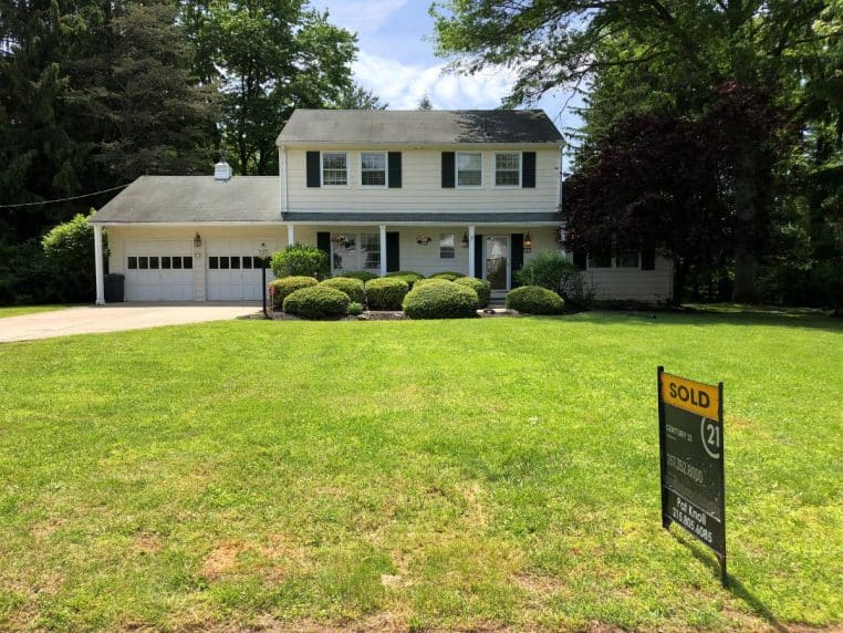 Maison individuelle avec panneau « Sold » au premier plan, représentant une transaction immobilière conclue.