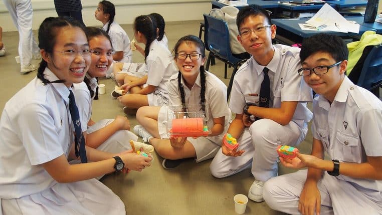 Élèves de Singapour en uniforme devant leur établissement, symbole d’un système scolaire performant d’Asie de l’Est.