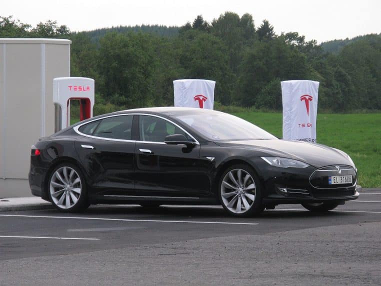 Tesla Model S noire en charge sur une aire avec bornes DC