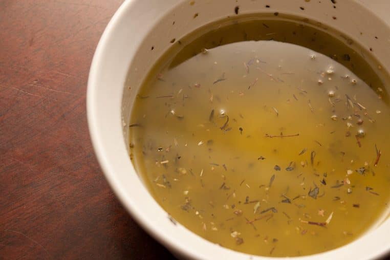 Bol de vinaigrette huile d’olive–citron sur table de cuisine.