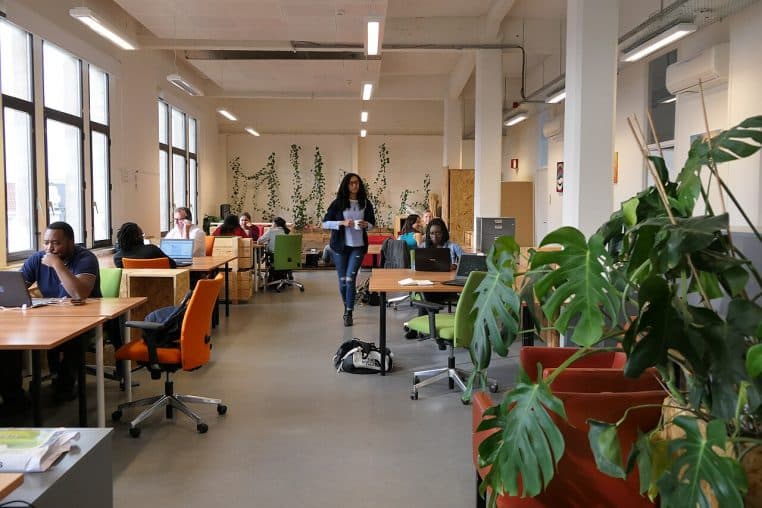 Open-space animé à Bruxelles, cadre de travail où la communication interne sur les salaires va se généraliser.