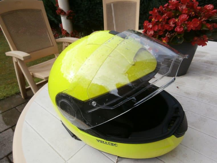Casque de moto avec visière dorée posé sur une surface
